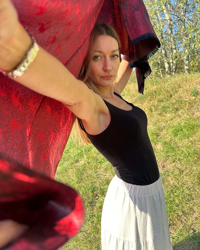 Czerwona chusta jedwabna z żakardowym wzorem karawany na tle natury