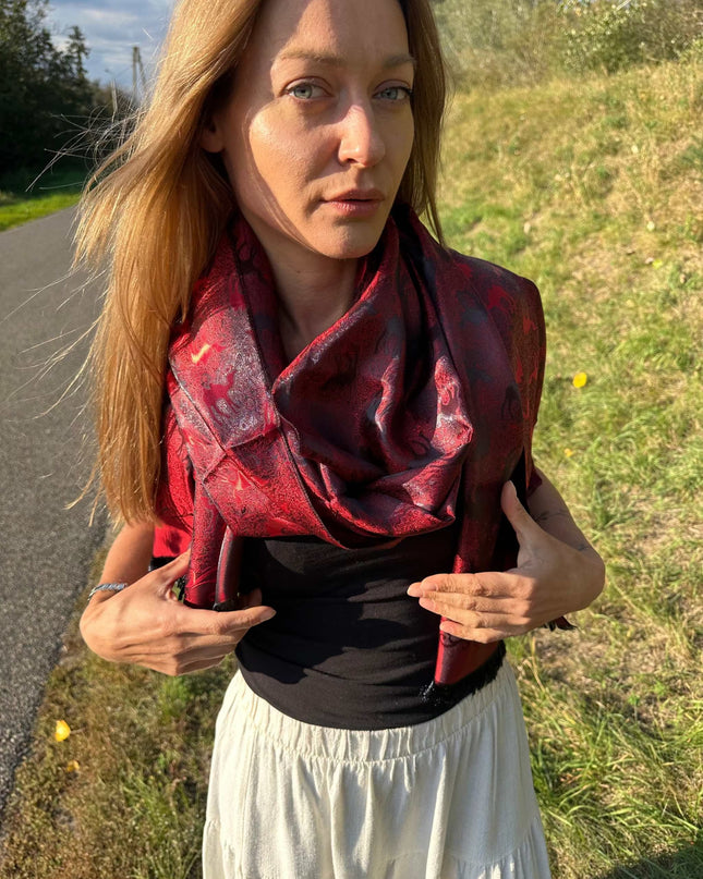 Czerwona chusta jedwabna o żakardowym wzorze karawany na kobiecie na zewnątrz