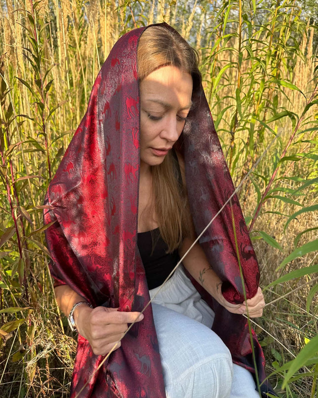 Czerwona chusta jedwabna z żakardowym wzorem karawany w naturalnym otoczeniu