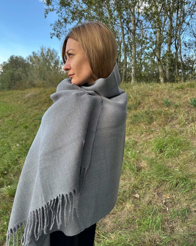 szary szal kaszmirowy o gęstym splocie w jodełkę z frędzlami na tle natury